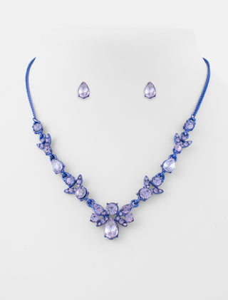 JUEGO DE COLLAR Y ARETES TIPO BROQUEL DE METAL AZUL CON PEDRERÍA EN FORMA DE BOLITAS Y GOTAS EN COLOR LILA - MICHELLE ACCESORIOS